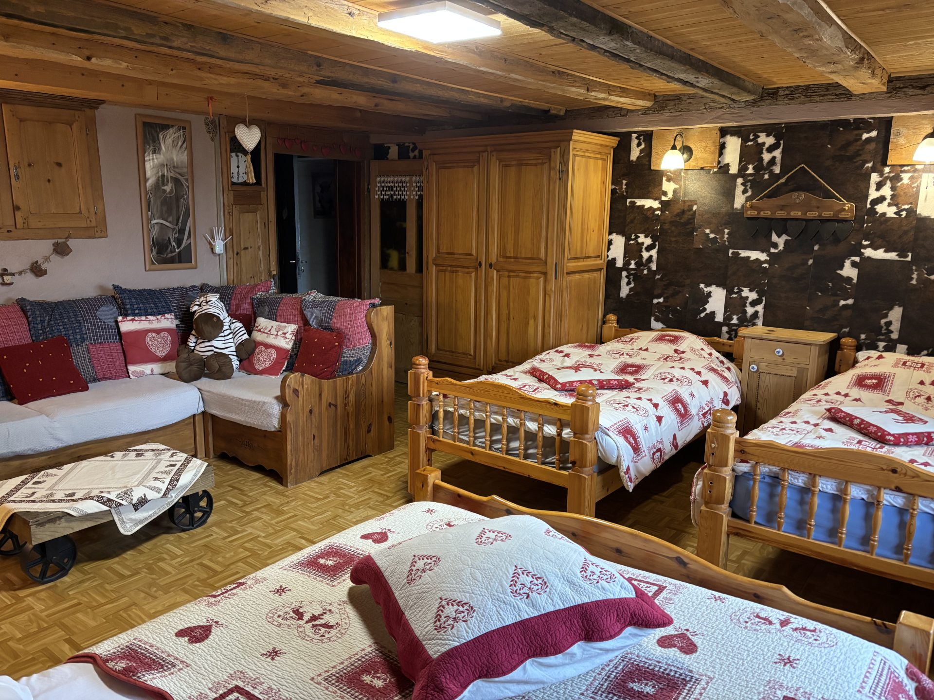 2ème chambre avec un lit double, deux lits simples et un canapé pour le coin télé
